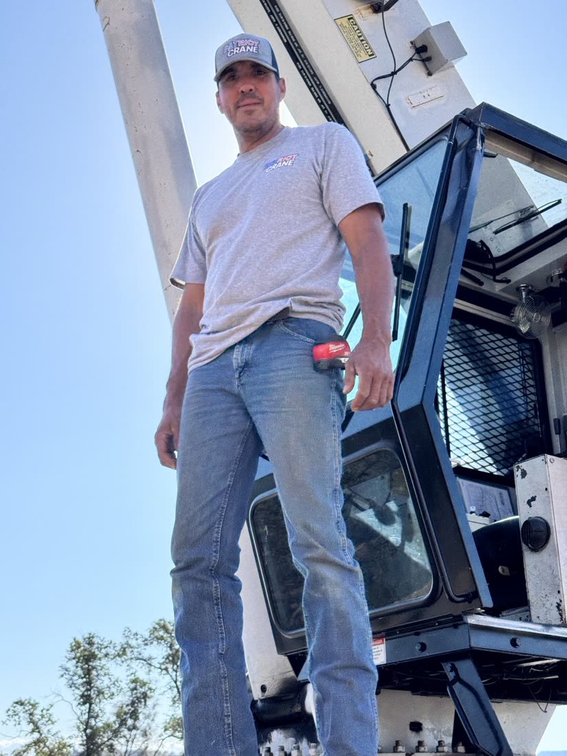 Rafael, owner and operator of Patriot Crane, standing on his rig