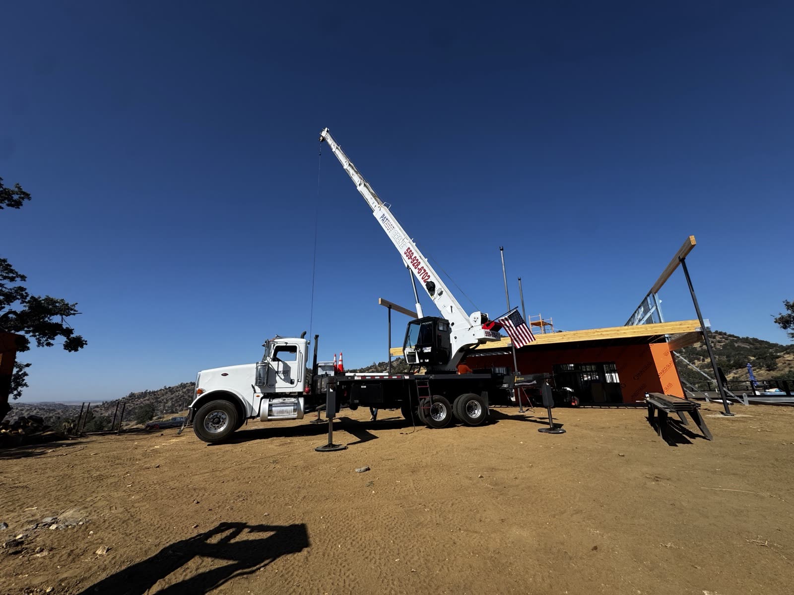 Patriot Crane set up on a hilltop build, flag flying and the number painted on the boom